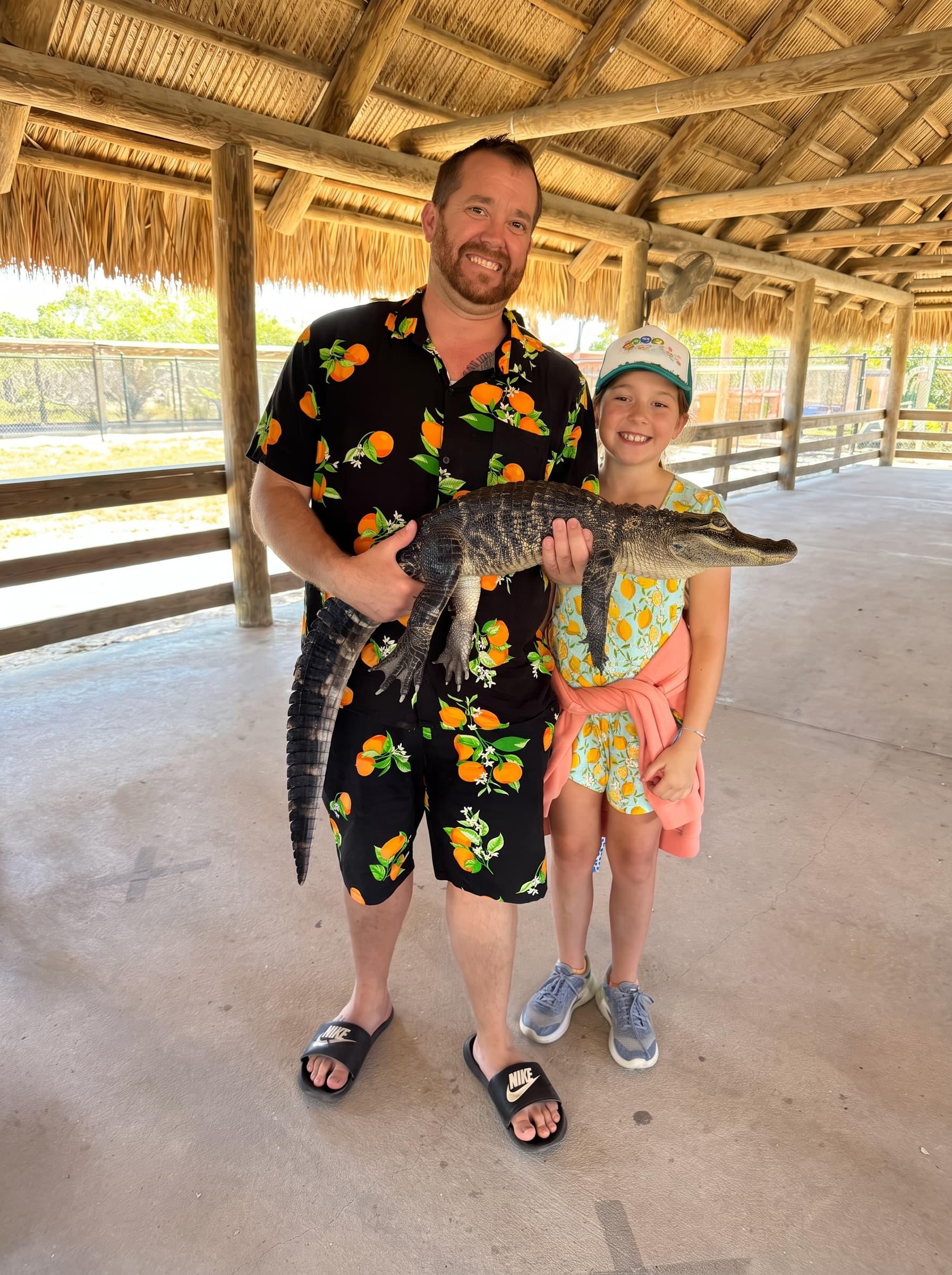 Matt smiling while holding a small alligator at a wildlife pavilion